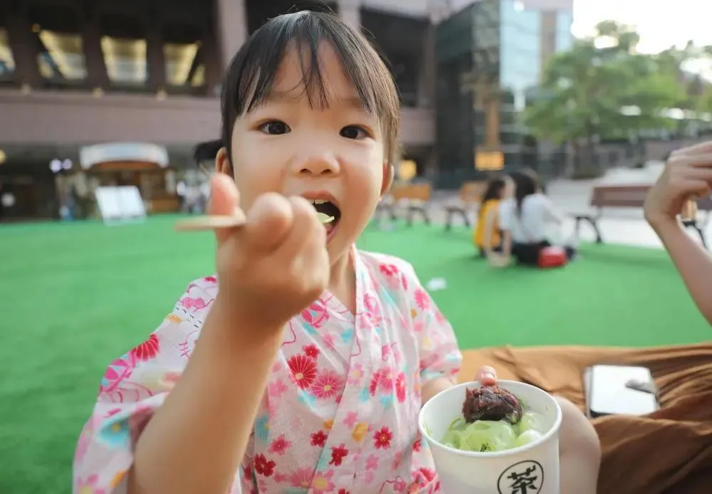 2019年7月30日,一个小女孩在日本东京吃抹茶冰淇淋。新华社记者 杜潇逸 摄
